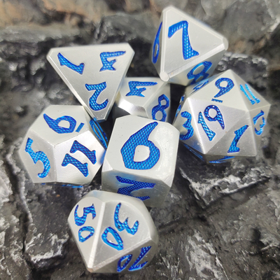 手はRPGのゲームのための青い銀製のPolyhedralダイス セットを包む絶妙なギフト用の箱とのDNDを切り分けた